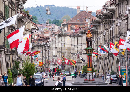 Kramgasse, Lebensmittelhändler Alley, Hauptstraße mit barocken Fassaden und Fahnen in der Altstadt von Bern, Schweiz Stockfoto