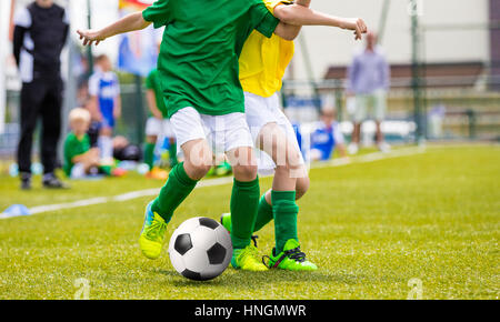 Fußball Fußball-Spiel für Kinder. Kinder spielen Fußball-Game-Turnier. Jungen laufen und Fußball auf dem Sport treten Grass Field Stockfoto