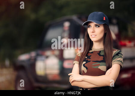 Fahrerin im Army-Outfit neben einem Off-Road Auto Stockfoto