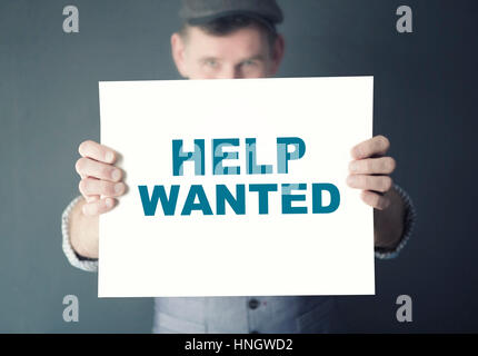 Mann hält ein Schild mit den Worten Help Wanted Stockfoto