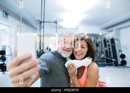 Älteres Paar in Turnhalle ruhen, wobei Selfie mit smartphone Stockfoto
