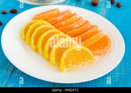 Gelee Bonbons in Form Zitrone Scheiben mit Zucker auf blauem Grund bedeckt. Stockfoto