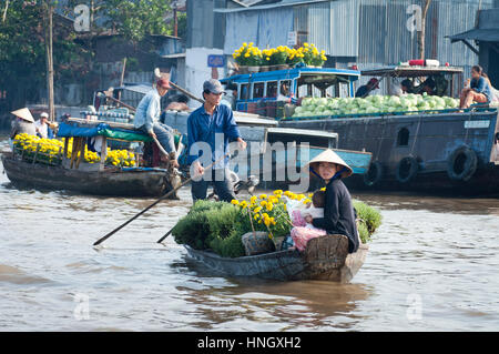 CAN THO, VIETNAM - Februar 1: Mann und Frau mit einem Baby auf einem Holzboot, beladen mit Pflanzen und Blumen auf dem schwimmenden Markt in Can Tho auf dem M Stockfoto