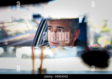 Istanbul, Türkei – 7. November 2009: Gesicht des Mannes spiegelt sich im Rückspiegel, wie er ein Taxi durch die Straßen von Istanbul fährt. Stockfoto