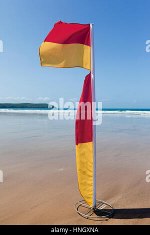 WOOLACOMBE, UK - 19 Mai: Rot und gelb Wimpel flattern im Wind auf Woolacombe Strand in Nord-Devon am 19. Mai 2011. Die Flagge wird von th verwendet. Stockfoto