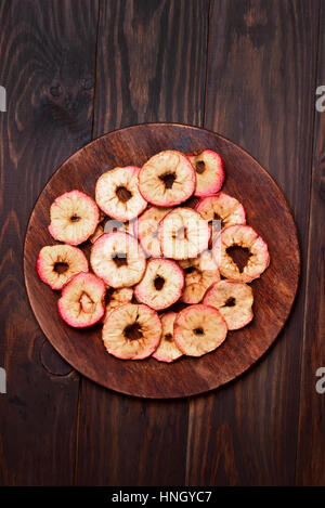 Äpfel-Chips auf Holzbrett, Ansicht von oben Stockfoto