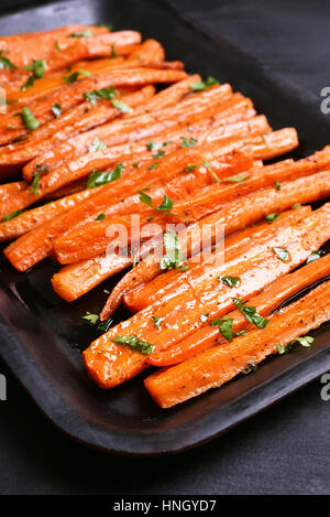 Gekochtes Gemüse, gebratene Karotten mit grünen Kräutern Stockfoto