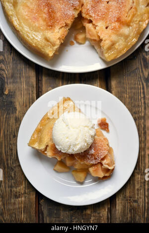 Stück Apfelkuchen serviert mit Eis Sahne, Obst Backen auf hölzernen Hintergrund, Ansicht von oben Stockfoto