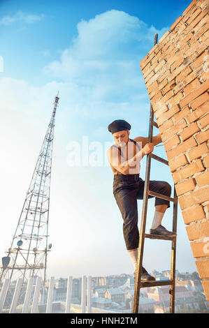 Gut aussehend-Generator auf Leiter hochklettern. Stockfoto