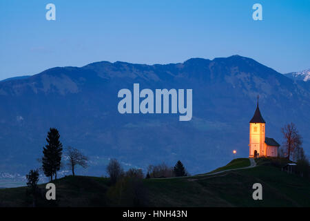Einsame Kirche auf dem Hügel bei Sonnenuntergang bei Jamnik, Slowenien Stockfoto