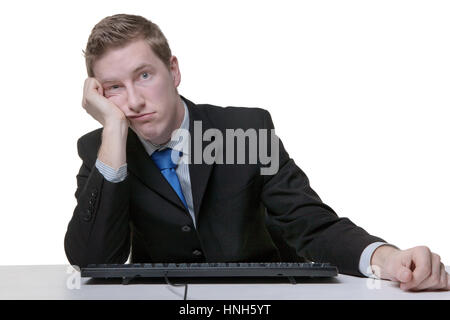Geschäftsmann gelangweilt bei der Arbeit sitzt an seinem Schreibtisch Stockfoto