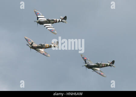 Drei Supermarine Spitfires, MkV, MkIX und ein T9 in einem Vic von drei mit einem Flypast in Duxford Airshow. Stockfoto