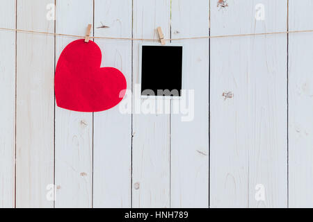 Rote Herzen und Foto Frame leer Holz weißen Hintergrund mit Platz auf der Wäscheleine hängen. Valentinstag. Stockfoto