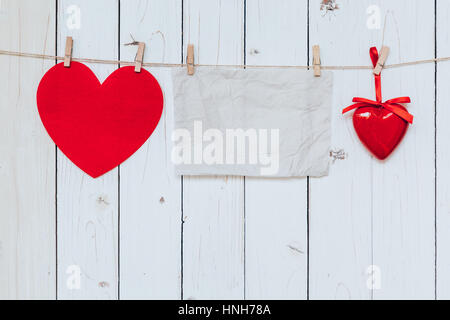 Rotes Herz und altem Papier leer Holz auf die Wäscheleine hängen, weißer Hintergrund mit dem Raum. Valentinstag. Stockfoto