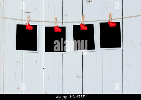 Vier Foto-Frame leer und roten Herzen hängen weiße Holz Hintergrund mit Raum Stockfoto