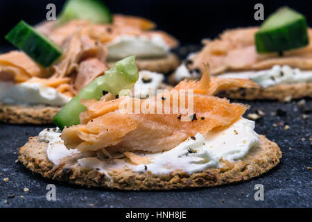 Lachs und Gurke Kanapees auf Haferkekse mit schwarzem Pfeffer Stockfoto