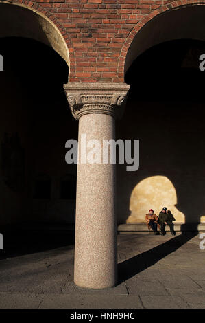 Paar, sitzen in der Sonne am Rathaus, Stockholm. Stockfoto