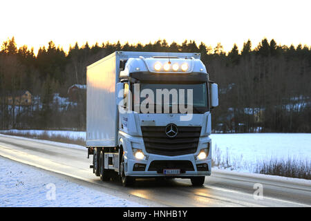 SALO, Finnland - 22. Januar 2017: Weiße Mercedes-Benz Actros LKW K Grahn Verkehrsmittel bewegt sich entlang der Autobahn bei Sonnenuntergang an einem Winternachmittag im Süden o Stockfoto