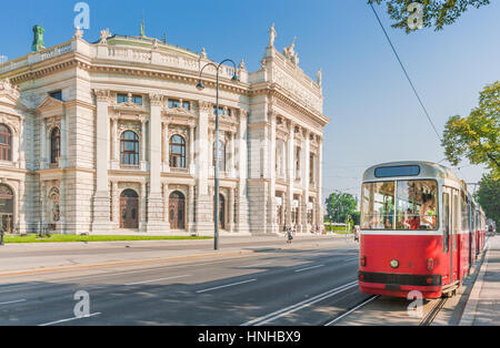 Klassische Ansicht der berühmten Wiener Ringstraße mit historischen Burgtheater (Imperial Court Theatre) und traditionelle rote elektrische Straßenbahn, Wien, Österreich Stockfoto