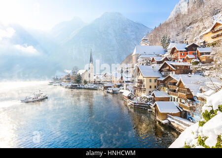 Klassische Postkartenblick auf berühmte Hallstätter See Stadt in den Alpen mit Passagier Schiff an einem schönen sonnigen Tag mit blauem Himmel und Wolken im winter Stockfoto