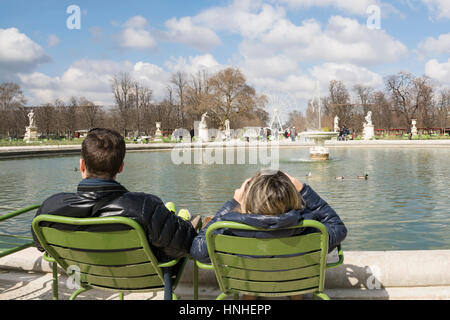 Paar, sitzen auf Stühlen vor einem Teich Ar Jardin des Tuileries, Paris, Frankreich Stockfoto