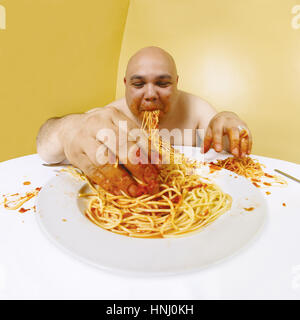 Foto von einem übergewichtigen Mann genießen einen Teller Spaghetti.  Schuss mit fisheye-Objektiv.  Schwerpunkt liegt auf dem Gesicht. Stockfoto