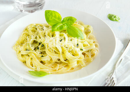 Tagliatelle Nudeln mit Pesto-Sauce, Käse und Basilikum Blätter auf weißen Teller - gesunde hausgemachte pasta Stockfoto