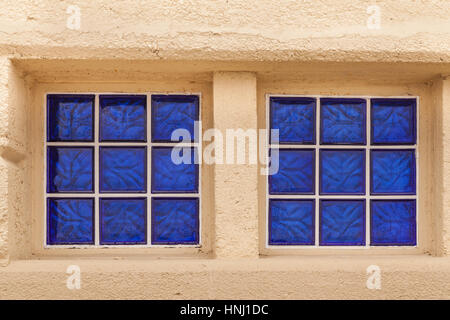 Lebendige blauen Fensterblöcke auf einem betonierten Strand-Gebäude Stockfoto