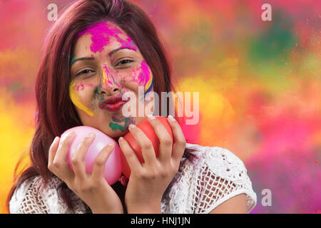Glückliche junge Inderin mit Holi Luftballons Holi Festival Stockfoto