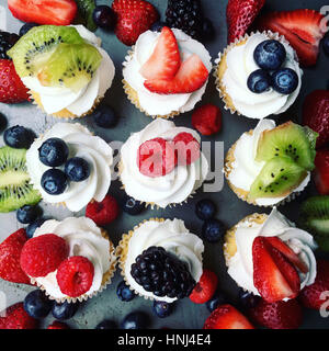 Draufsicht der Cupcakes, garniert mit Früchten auf Tisch Stockfoto