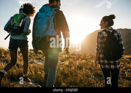 Rückansicht-Schuss von jungen Freunden in Landschaft während Sommerurlaub wandern. Gruppe von Wanderern, die lange Spaziergänge in der Natur. Stockfoto