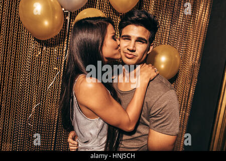 Aufnahme des jungen Liebespaar im Night Club. Junge Frau küssen ihren Freunden in der Partei im Pub. Stockfoto