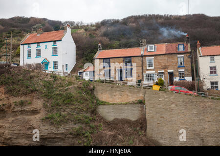 Die Häuser auf der steilen Hügel in Staithes, North Yorkshire, England, Großbritannien führenden mit Rauch aus Schornsteinen Stockfoto