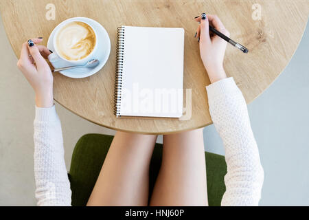 Zarte Frauenhand schreiben in notebook Stockfoto