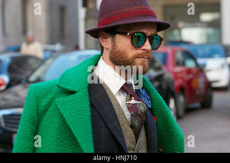 Mann mit grünen Jacke und lila Hut vor Salvatore Ferragamo Modenschau, Milan Fashion Week Streetstyle am 15. Januar 2017 Stockfoto