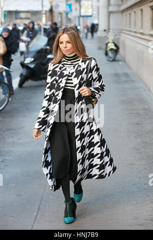 Erica Pelosini mit schwarzen und weißen pied de Poule Mantel vor Salvatore Ferragamo Modenschau, Milan Fashion Week Streetstyle am Januar 2017. Stockfoto