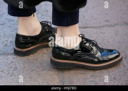 Frau mit schwarzem Lackleder englische Schuhe vor Salvatore Ferragamo Modenschau, Milan Fashion Week Streetstyle am Januar 2017. Stockfoto