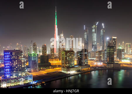 Skyline von Dubai downtown in der Nacht. Burj Khalifa in Nationalfarben der VAE - grün, rot und weiß beleuchtet. Vereinigte Arabische Emirate, Naher Osten Stockfoto