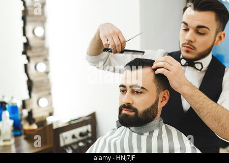 Dunklen Haaren Friseur einen Haarschnitt zu tun Stockfoto
