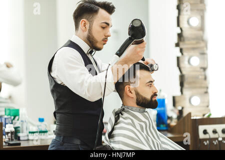 Dunklen Haaren Friseur einen Haarschnitt zu tun Stockfoto