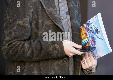 Mann mit grünen Blumen Mantel und Smartphone vor Etro Modenschau, Milan Fashion Week Streetstyle am 16. Januar 2017 in Mailand. Stockfoto