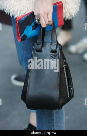 Frau mit kleinen Loewe schwarz Ledertasche vor MSGM Modenschau, Milan Fashion Week Streetstyle am 16. Januar 2017 in Mailand. Stockfoto