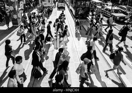 Hong Kong, Hong Kong - 17. April 2015: Menschen überqueren eine Straße in Hong Kong Insel zentralen Stadtteil. Gefangen in schwarz und weiß mit einem starken Kontrast. Stockfoto