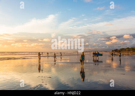 BALI, Indonesien - 21. Februar 2016: Touristen genießen Sie einen atemberaubenden Sonnenuntergang am Strand von Kuta im Bereich Seminyak der beliebten Insel in Indonesien. Stockfoto