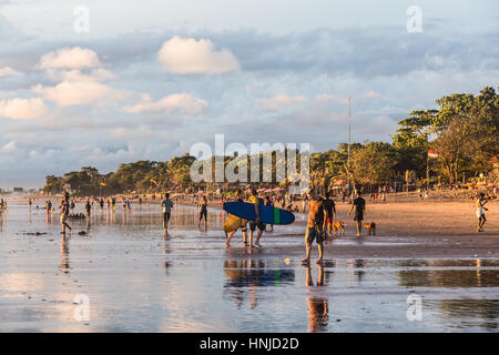 BALI, Indonesien - 21. Februar 2016: Touristen genießen Sie einen atemberaubenden Sonnenuntergang am Strand von Kuta im Bereich Seminyak der beliebten Insel in Indonesien. Stockfoto