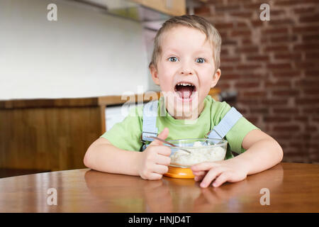 Fünf Jahre Junge öffnete seinen Mund porridge Küche Stockfoto