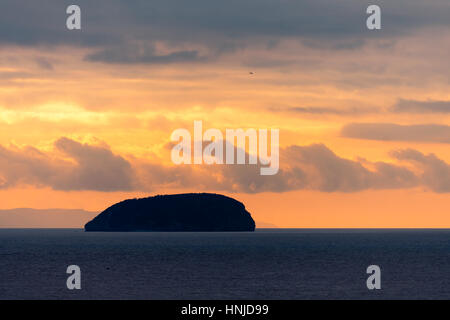 Sonnenuntergang hinter dem steilen Holm Insel in den Bristolkanal. Spektakuläre Himmel und Wolken von Weston-super-Mare in Somerset, England, an den hohen Gezeiten gesehen Stockfoto