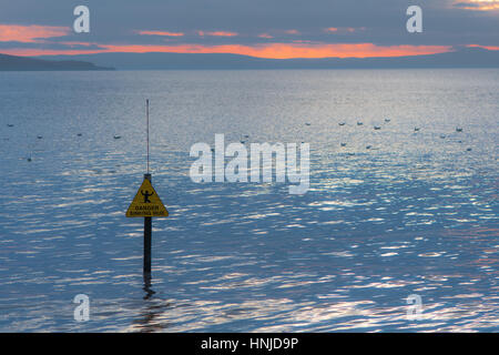 Gefahrenzeichen Schlamm versinken vor auf Meer und Sonnenuntergang. Warnung vor gefährlichen Küste bei Weston-super-Mare, Somerset, UK, mit Brean Down und Möwen Stockfoto