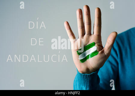 den Text Dia de Andalucia, Tag in Andalusien auf Spanisch und die Flagge von Andalusien, Spanien, gemalt in der Handfläche der kaukasischen Jüngling Stockfoto