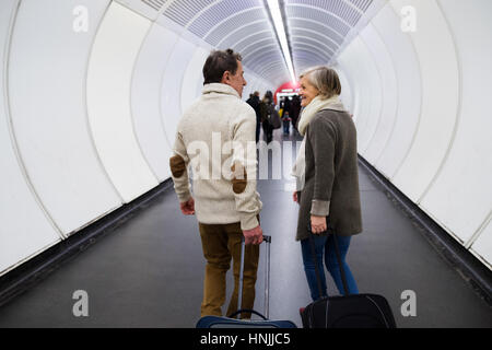 Älteres Paar im Flur der u-Bahn ziehen Trolley Gepäck. Stockfoto
